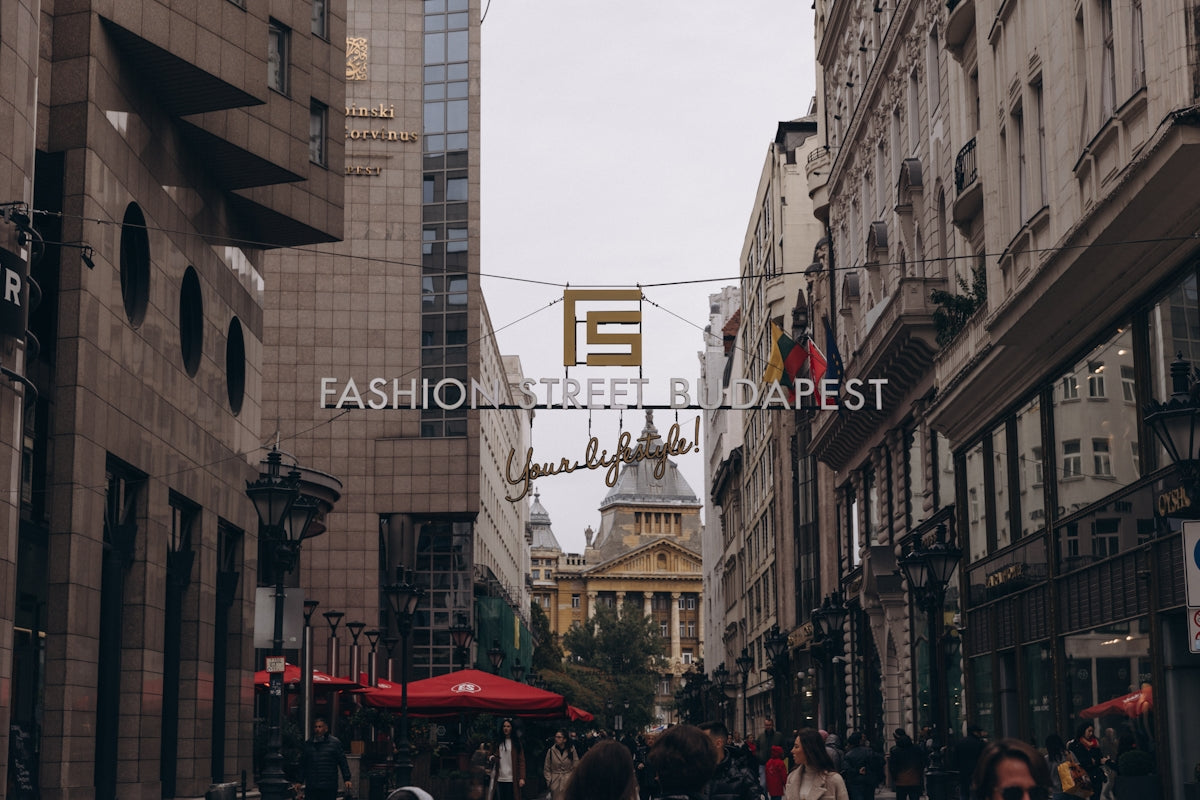 a group of people walking down a street next to tall buildings