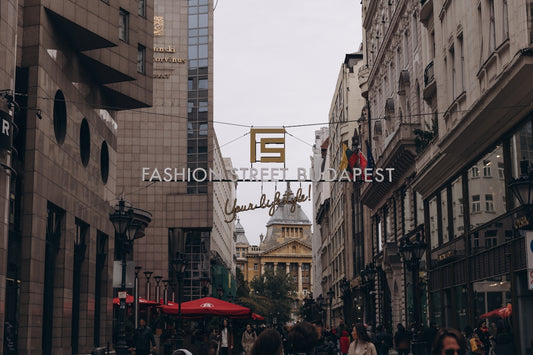 a group of people walking down a street next to tall buildings