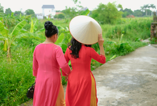 two women wearing dresses and hats