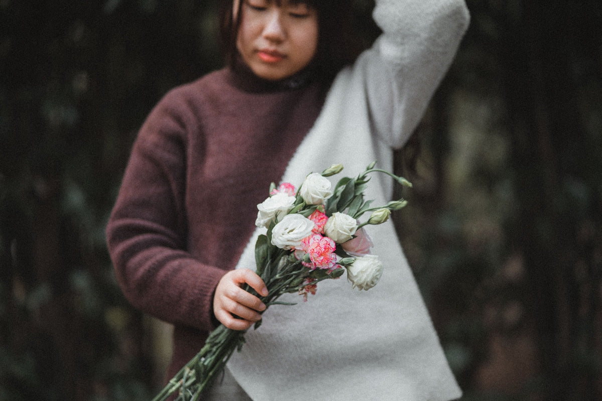 a woman is holding a bouquet of flowers