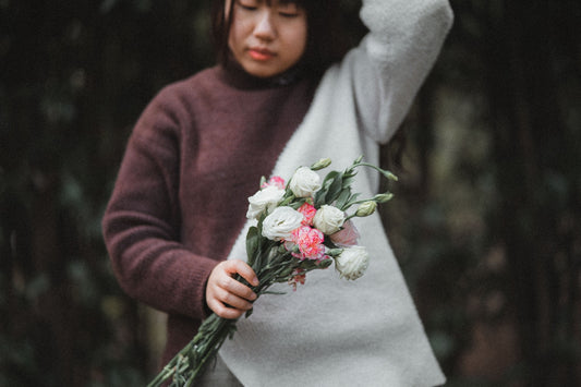 a woman is holding a bouquet of flowers