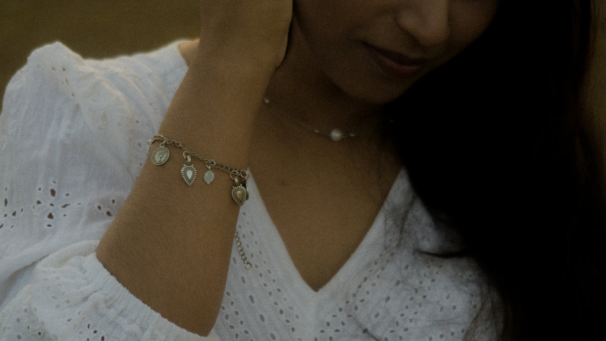 Woman with jewelry is holding her neck.