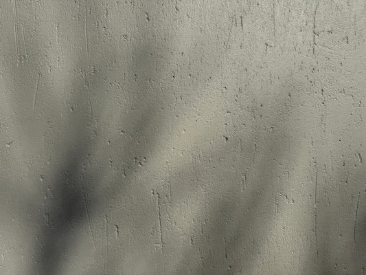 Shadows fall across a textured, gray surface.