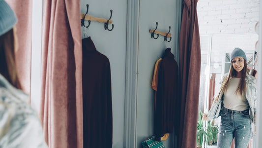 Woman tries on clothes in a dressing room.