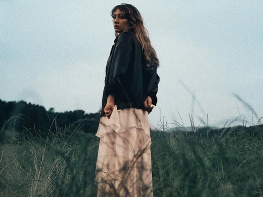 Woman in a dress standing in a grassy field
