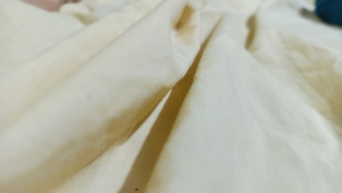 Close-up of a textured, cream-colored fabric.