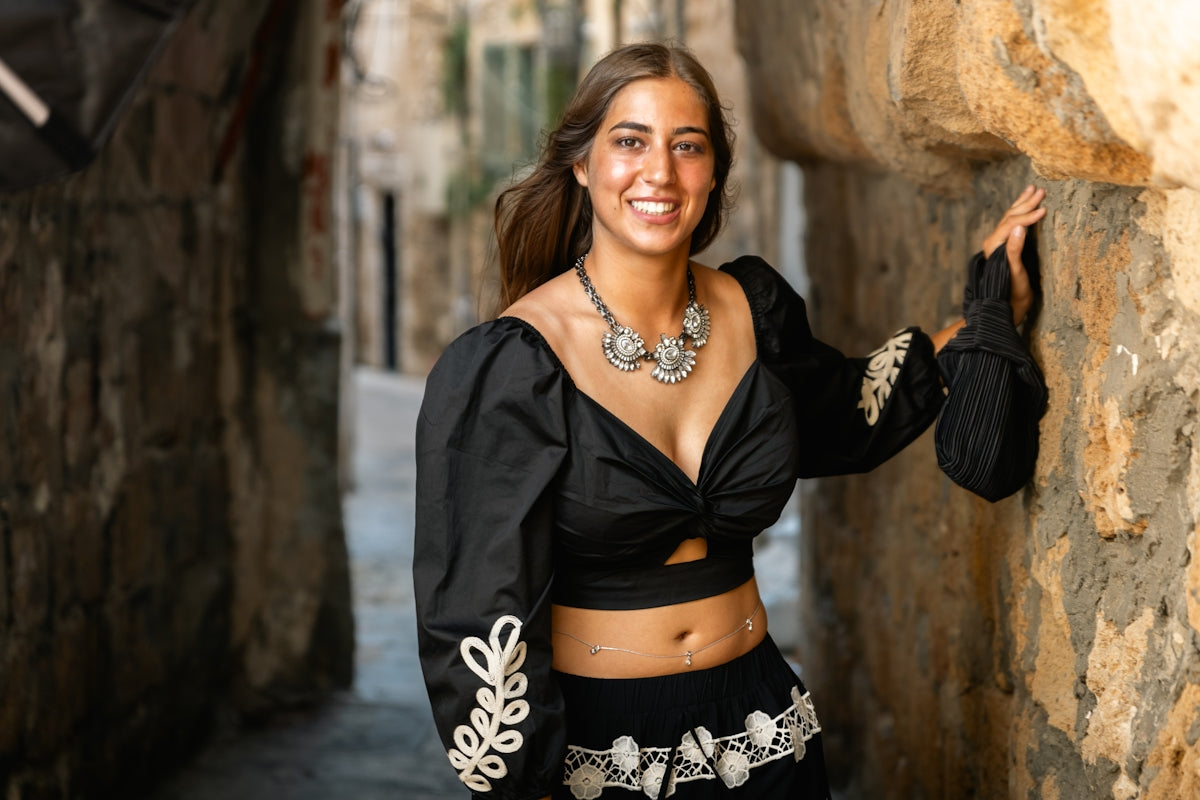 Young woman in black outfit in narrow alleyway