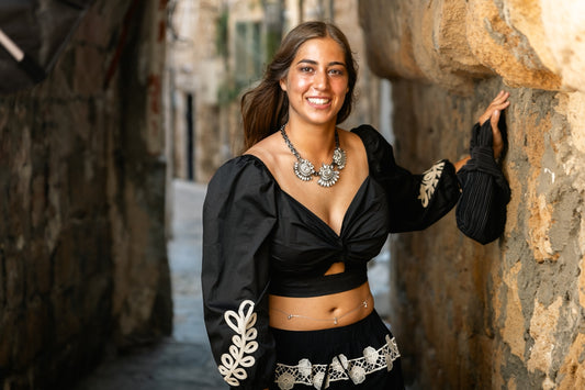 Young woman in black outfit in narrow alleyway