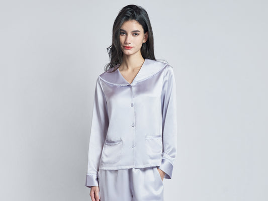 A woman wearing a light purple silk pajama set.