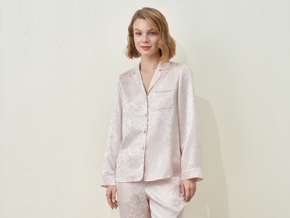 A woman wearing a light pink patterned pajama set.