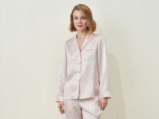A woman wearing a light pink patterned pajama set.