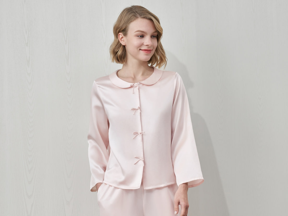 A woman in a pink silk pajama set