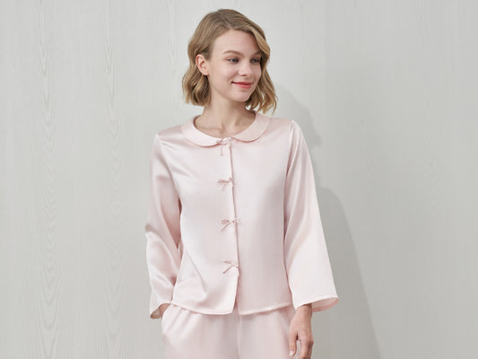 A woman in a pink silk pajama set