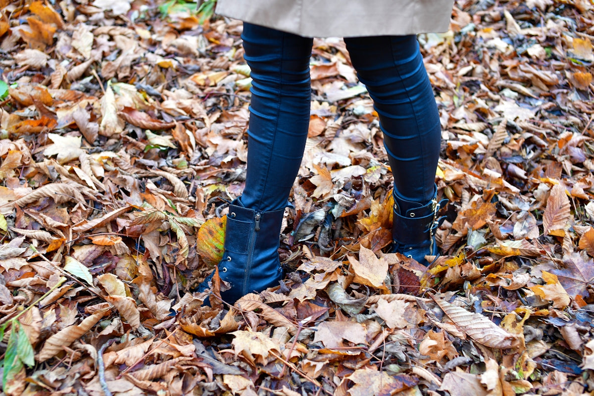 Person standing on a pile of fallen autumn leaves.