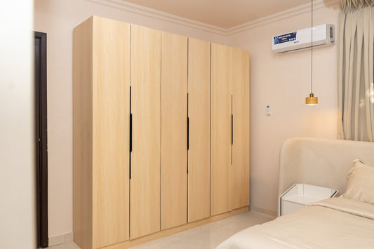 Modern light wood wardrobe in a clean bedroom interior.