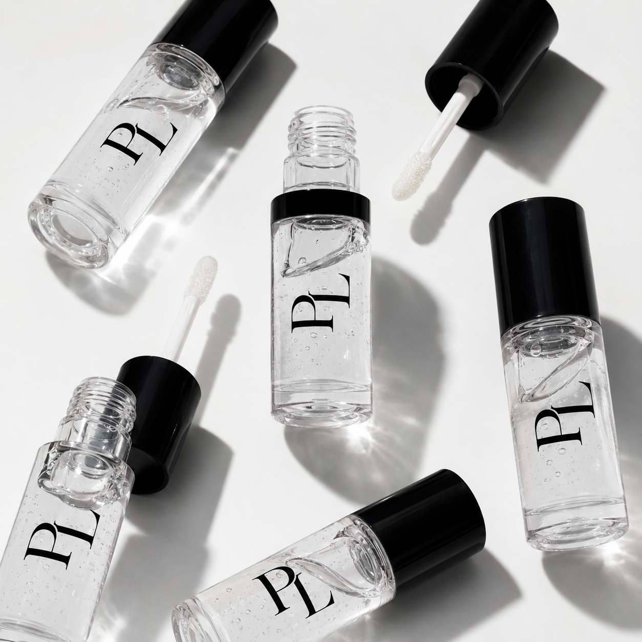 Set of small clear bottles with black caps on a white background
