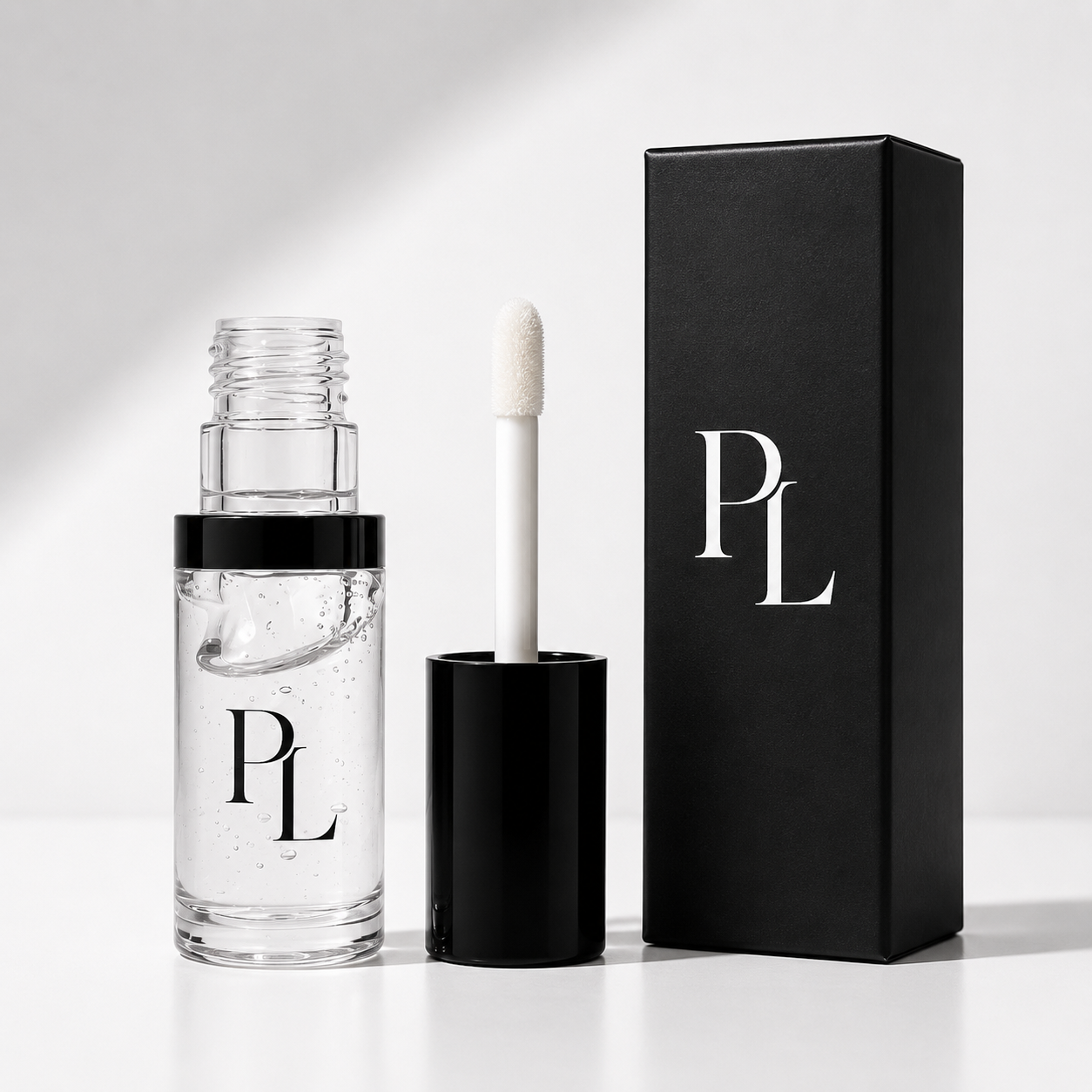 Clear lip gloss with applicator and black box featuring 'PL' logo on a light gray background